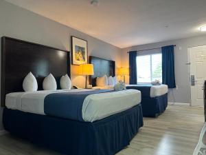 Habitación de hotel con 2 camas y ventana en Lantern Inn & Suites - Sarasota, en Sarasota