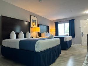 a hotel room with two beds and a window at Lantern Inn & Suites - Sarasota in Sarasota