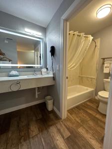 y baño con lavabo, bañera y aseo. en Lantern Inn & Suites - Sarasota en Sarasota