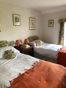 ein Hotelzimmer mit 2 Betten und 2 Stühlen in der Unterkunft Georgian Farmhouse in Castle Douglas