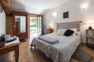 a bedroom with a bed and a table and a mirror at Les Filolies in Saint-André-dʼAllas