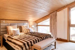 a bedroom with a large bed with a wooden ceiling at Résidence Carre Blanc - 4 Pièces pour 6 Personnes 434 in Courchevel