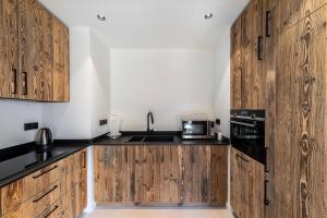 una cocina con armarios de madera y fregadero en Résidence Horizon Blanc - 4 Pièces pour 6 Personnes 314, en Courchevel