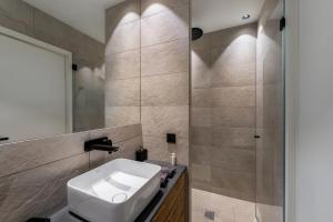 y baño con lavabo y ducha. en Résidence Horizon Blanc - 4 Pièces pour 6 Personnes 314, en Courchevel