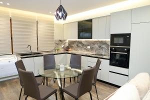a kitchen with a glass table and chairs at Green Villa with Private Pool in Durrës
