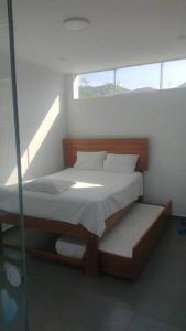 1 dormitorio con 1 cama y pared de cristal en Casa Elizabeth - Recreate, en Mala