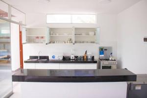 cocina con armarios blancos y encimera negra en Casa Elizabeth - Recreate, en Mala