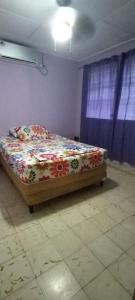 a bedroom with a bed in a room with blue curtains at Tu casa lejos de tu casa in David