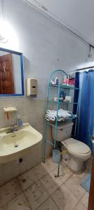 a bathroom with a toilet and a sink and a mirror at Tu casa lejos de tu casa in David
