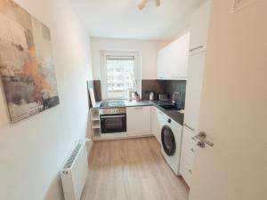 una pequeña cocina con lavadora y secadora. en RR - NEW - Gorgeous 50qm Apartment - Washer - WIFI, en Rusches Hof