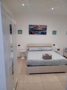 バーリにあるHouse del Levanteの白いベッドルーム(ベッド1台付)が備わります。壁には絵画が飾られています。