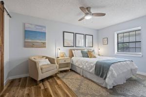 a bedroom with a bed and a chair and a ceiling fan at Collinson Ct Retreat | Palm Coast in Palm Coast +42 photos