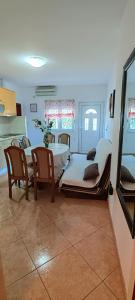 Cette chambre comprend deux lits, une table et des chaises. dans l'établissement Apartmani Milicevic, à Igalo