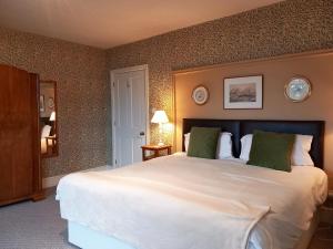 een slaapkamer met een groot wit bed met groene kussens bij Haslington House in Malvern Wells