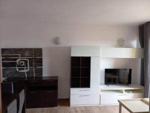 una cocina con armarios blancos y TV. en Apartamento Babor Golf Almerimar, en Almerimar