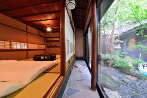 a bedroom with a bed and a large window at Takeya Kitano Honkan in Kyoto