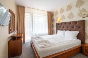 - une chambre avec un lit doté de draps blancs et une fenêtre dans l'établissement Complex Katalina, à Tsigov Chark
