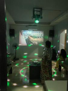 a woman standing in a room with a projection screen at Camotes Resthouse in Camotes Islands