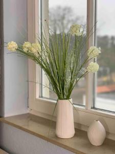 グラール・ミューリッツにあるdiscovAIR Graal-Müritz -Villa Victoria- Strandnah mit Netflixの窓枠に花を飾る白花瓶
