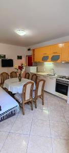 une cuisine avec une table et des chaises et une cuisine avec des placards dans l'établissement Apartmani Milicevic, à Igalo
