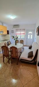 - une cuisine et une salle à manger avec une table et des chaises dans l'établissement Apartmani Milicevic, à Igalo