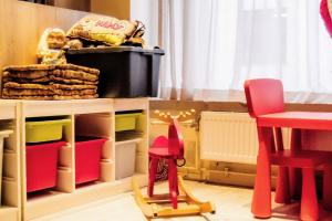 una stanza giocattolo con tavolo e sedie e una stanza giocattolo con tavolo di Hotel des Postes a Houffalize