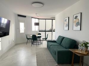 sala de estar con sofá verde y mesa en Jandia Beach Apartment 2, en Morro del Jable