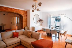 een woonkamer met een bank en een eetkamer bij Villa Miracampo - Elegant Secret in Albufeira