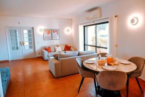 een woonkamer met een tafel en een bank bij Villa Miracampo - Elegant Secret in Albufeira
