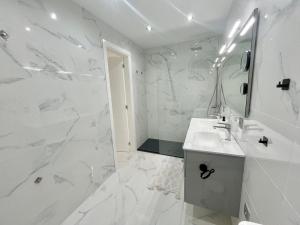 a white bathroom with a sink and a mirror at Jandia Beach Apartment 2 in Morro del Jable +34 photos