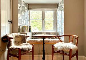 een kamer met 2 stoelen, een tafel en een raam bij The Bolt in Lynmouth