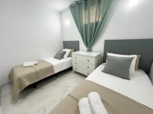 1 Schlafzimmer mit 2 Betten und einem Fenster in der Unterkunft Jandia Beach Apartment 2 in Morro del Jable