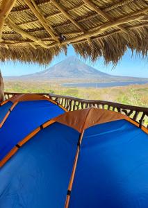 a tent with a view of a mountain in the distance at Hostel & Camping Sol Y Luna Ometepe in Balgue