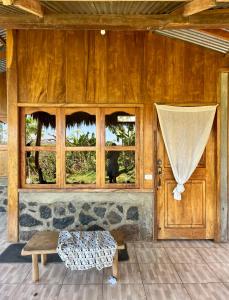 Habitación con puerta de madera y ventana en Hostel & Camping Sol Y Luna Ometepe, en Balgue