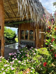 Balgue的住宿－Hostel & Camping Sol Y Luna Ometepe，一座花园,在一座建筑前种有鲜花