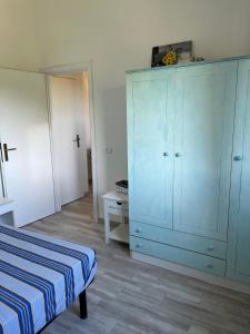 1 dormitorio con 1 cama y armario azul en Porto Coda Cavallo Salina Bamba, en Capo Coda Cavallo