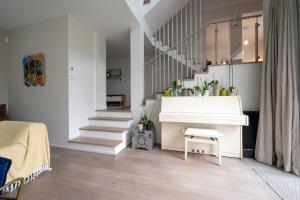 a living room with a white piano and stairs at Large villa with garden in Suresnes - Welkeys in Suresnes