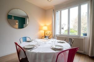a dining room with a table with chairs and a mirror at Large villa with garden in Suresnes - Welkeys in Suresnes
