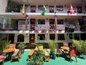 a courtyard with tables and chairs and a building at El Jardín Escondido Party Hostel in Baños