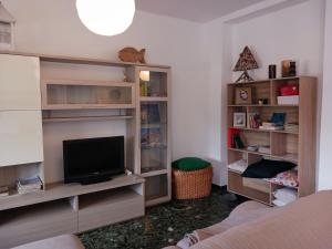 een woonkamer met een tv en enkele planken bij Comoda posizione, per 5-TERRE, PortoVenere, Lerici in La Spezia