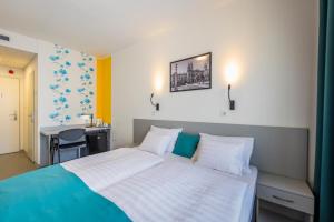 1 dormitorio con 1 cama grande y escritorio en Arrabona HotelRooms, en Győr