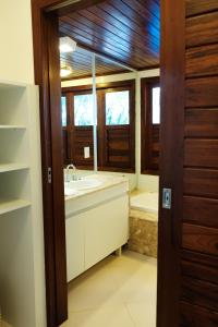 a bathroom with a sink and a tub and windows at Refúgios Parajuru - Villa Cacau in Parajuru