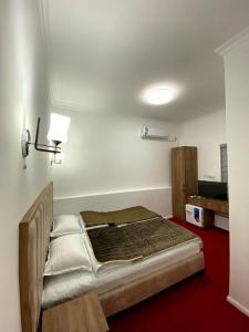 a bedroom with a bed in the corner of a room at Alifa Lux Guesthouse in Samarkand