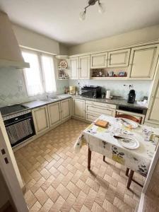 eine Küche mit einem Tisch in der Mitte in der Unterkunft Location maison saisonnière in Pleurtuit