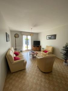 ein Wohnzimmer mit 2 Sofas und einem TV in der Unterkunft Location maison saisonnière in Pleurtuit