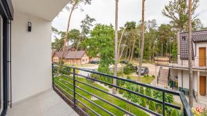a balcony with a view of a street at Prestige House Apartament - 2 sypialnie z ogródkiem i basenem in Pobierowo +35 photos