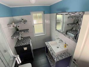 y baño con lavabo y espejo. en discovAIR Graal Müritz -Haus Quisisana- Strandnah mit Netflix, en Graal-Müritz
