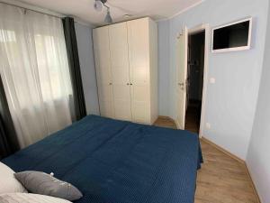 een slaapkamer met een blauw bed en een kast bij discovAIR Graal Müritz -Haus Quisisana- Strandnah mit Netflix in Graal-Müritz