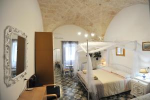a bedroom with a bed and a mirror and a table at B&B CASAVACANZE CHIESA MADRE in Carovigno