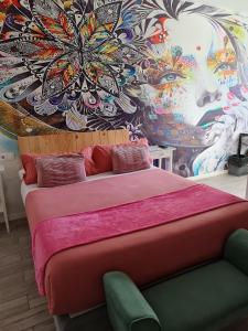1 dormitorio con 1 cama grande y pared colorida en Huelva Art, en Huelva
